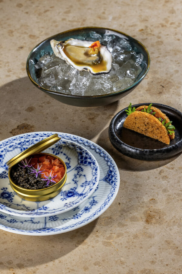 Take away by cortsen - marts april menu 2025 - snacks - Pocheret gillardeau med passionjuice med olivenolie, sød passionscreme med batakpeber, tagetes og friterede skorzonerrødder Caviar en surprise med jomfruhummer i sød og pebret tomatcreme med buratta, let spicy tomatconcasse og caviar Toast melba med okse i peberrod