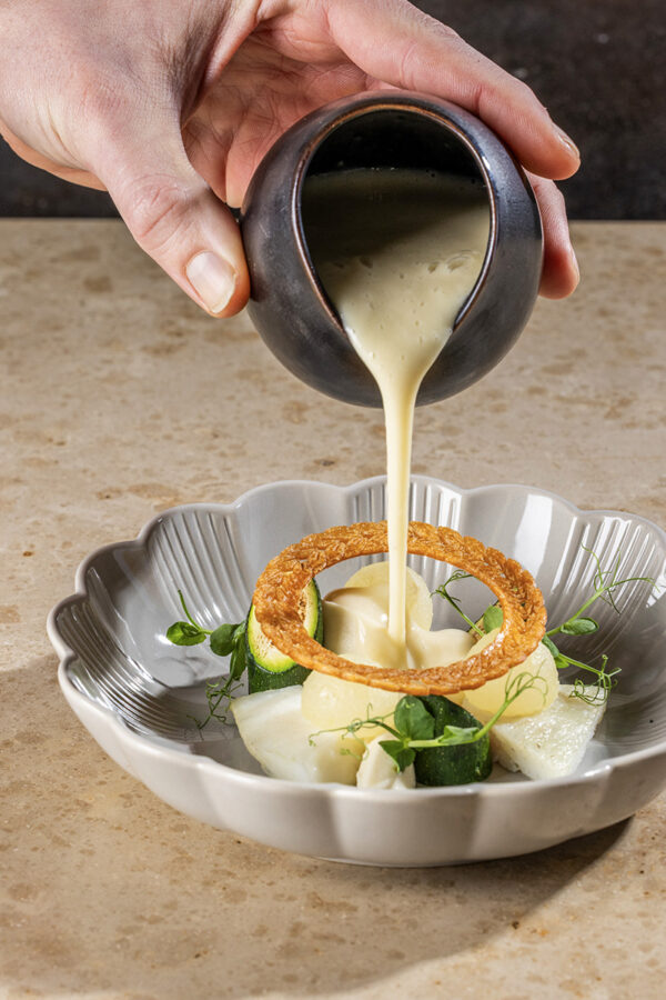 Take away by cortsen - marts april menu 2025 - forret - Pighvar med grillet zuchinni, sprød nashipære og pure af persillerod i brunet smør. Sprød løgchip og røget pighvarsauce