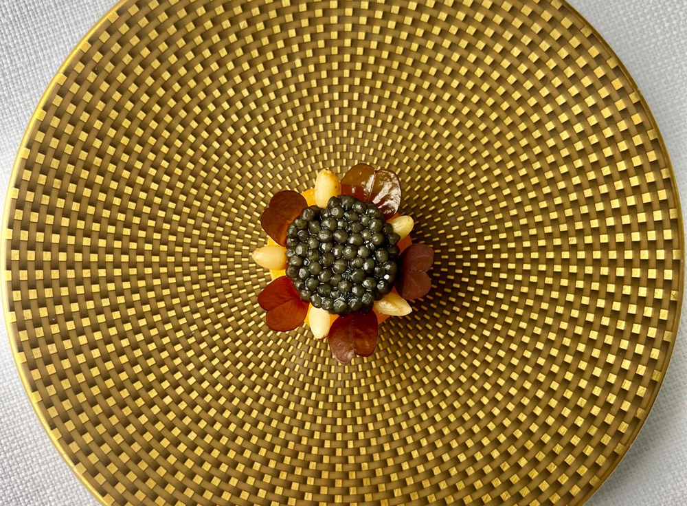 Cantaloup infuseret i mandelolie med pebret friskost og citrus, caviar og ristede pinjekerner